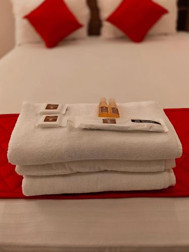 a pile of towels sitting on top of a bed at MKR GRANd in Rāmeswaram