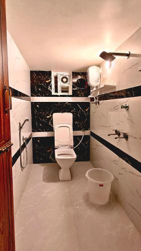 a bathroom with a white toilet and a sink at MKR GRANd in Rāmeswaram