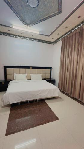 a bedroom with a large bed with a painting on the ceiling at السلطان هاوس in Najran