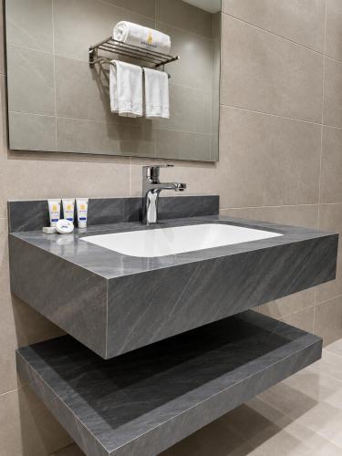 a large sink in a bathroom with a mirror at Al Quba Palace Serviced Apartments in Riyadh