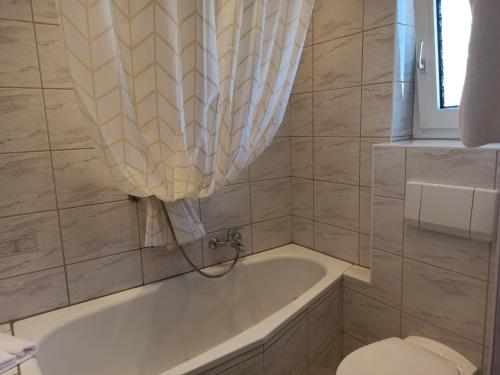 a bathroom with a tub and a toilet and a sink at Gästehaus Gartenstraße 5 vom Central Hotel in Schwetzingen