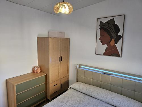 a bedroom with a bed and a dresser and a cabinet at O Alpendre in Bueu