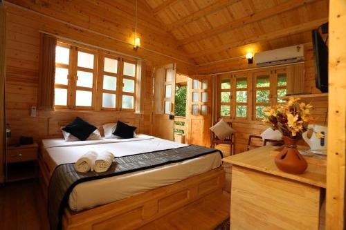 a bedroom with a bed in a wooden cabin at Silver Green Resort in Wayanad