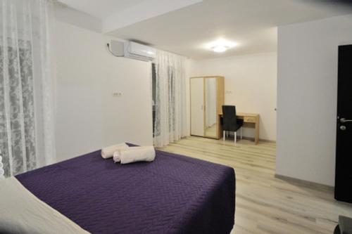 a bedroom with a purple bed with two towels at Villa Paradiso By Italy in Mostar