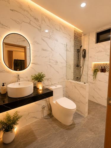 a bathroom with a toilet and a sink and a mirror at Prukrom Lanta Villa in Ko Lanta