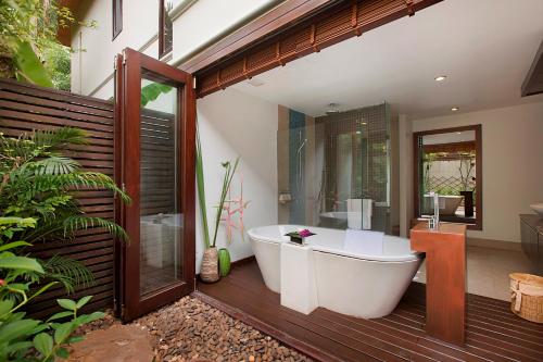 a bathroom with a bath tub on a wooden deck at Dhevatara Cove in Lipa Noi