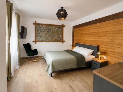 a bedroom with a bed and a chair in it at Villa Franca Luxury Chalets in Sighişoara