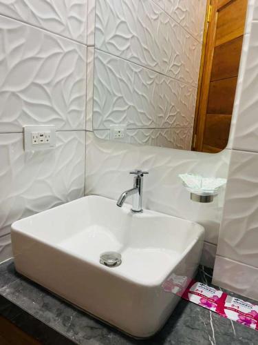 a white sink in a bathroom with a mirror at studio confort in Iquitos