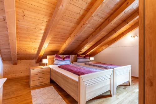 a bed in a room with a wooden ceiling at Kramerhof - Ferienwohnung Wallberg in Aufhofen
