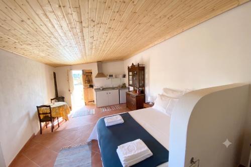 a bedroom with a bed and a kitchen with a table at Kochab Alentejo in Crato