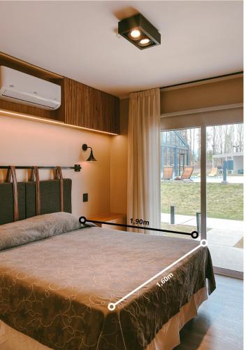 a bedroom with a bed and a large window at TERMAS PISMANTA Hotel & Spa in Las Flores