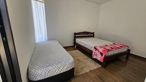 a room with two beds and a window at Suítes Ninho dos Lobos in Pardinho