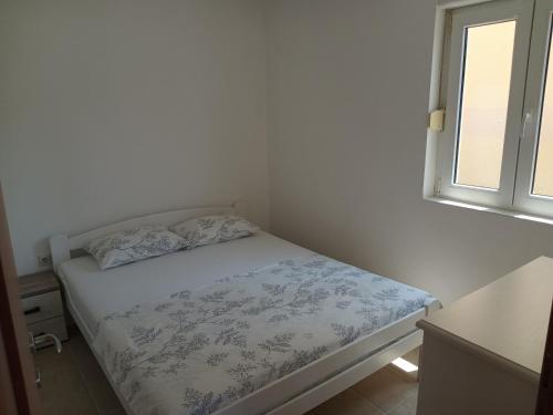 a small bed in a room with a window at Kumbor S in Herceg-Novi