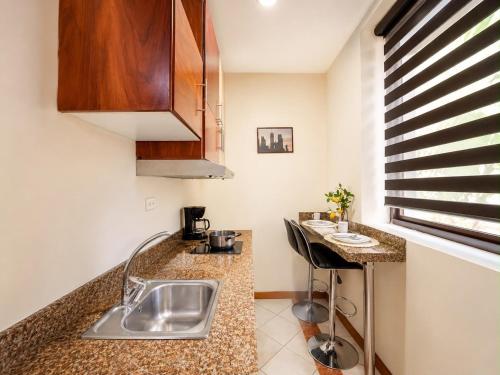 a kitchen with a sink and a counter at Suite Tarqui en el Centro Histórico in Cuenca