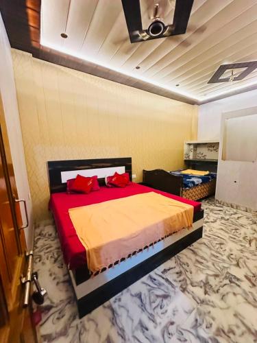 a bedroom with a bed with red pillows on it at Lakshman Guest House Ayodhya in Jāmb