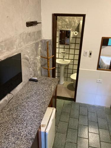 a bathroom with a sink and a toilet in a room at Papagaio Hostel & Pousada in Morro de São Paulo