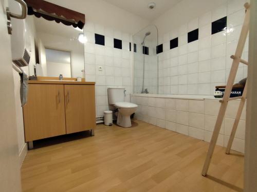 a bathroom with a toilet and a tub and a sink at L'insolite comblée in Ustou