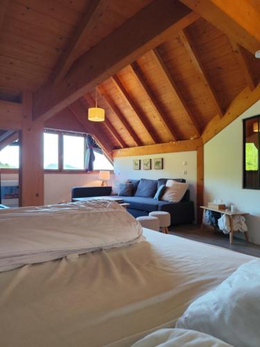a bedroom with a bed and a blue couch at L'insolite comblée in Ustou
