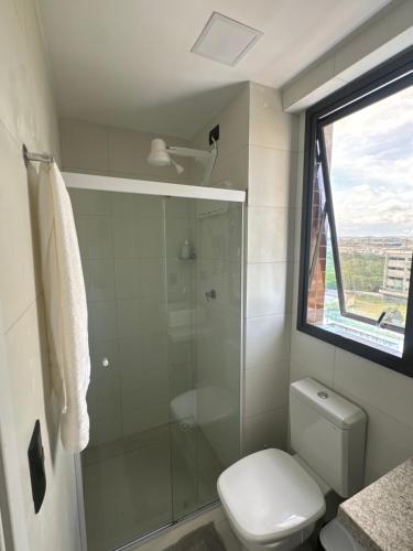 a bathroom with a shower and a toilet and a window at Flat no bairro universitário in Caruaru