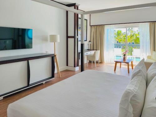 a hotel room with a bed and a television at Ocean Blue & Sand Beach Resort - All Inclusive in Punta Cana