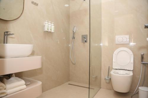 a bathroom with a shower and a toilet and a sink at Terminal Hotel in Krujë
