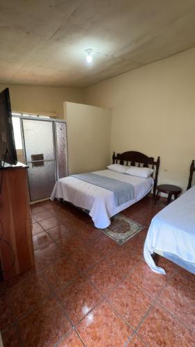 a bedroom with two beds and a flat screen tv at Accommodation #6 in Copán Ruinas in Copán Ruinas