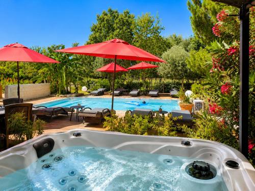 a jacuzzi tub in a yard with a pool at Villa Alyzea Chambre d'hôtes réservée aux adultes in Bessan
