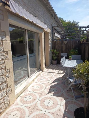 a patio with a table and a bench on it at Maison Cocooning Equihen 5 pers Proche Mer & Terrasse in Équihen-Plage