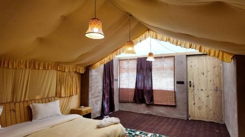 a bedroom with a bed and a window at Mystique Meadows Swiss Cottages in Nubra