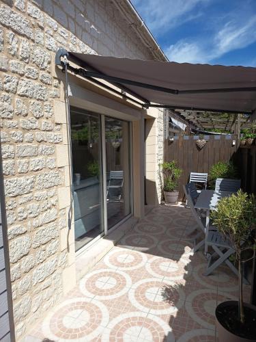 a patio with an umbrella on a brick building at Maison Cocooning Equihen 5 pers Proche Mer & Terrasse in Équihen-Plage