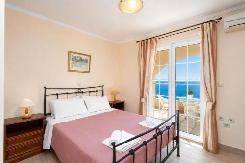 a bedroom with a bed and a view of the ocean at Ioannas House in Nisaki