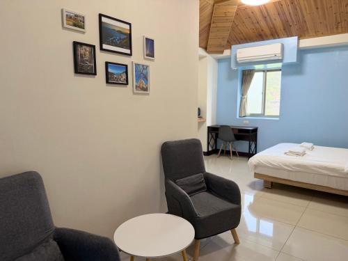 a bedroom with a bed and a chair and a table at 好馨情民宿 in Nangan