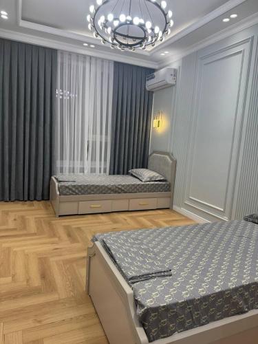 a bedroom with two beds and a chandelier at NRG BI Sado in Katartal