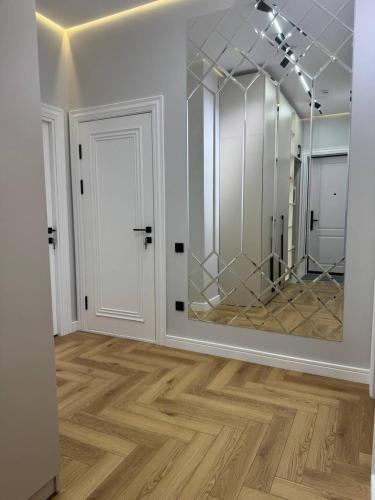 a room with a mirror and a white door at NRG BI Sado in Katartal