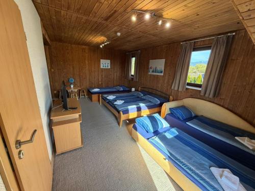 a room with four beds and a tv in it at Liptovsky Zrub in Gôtovany