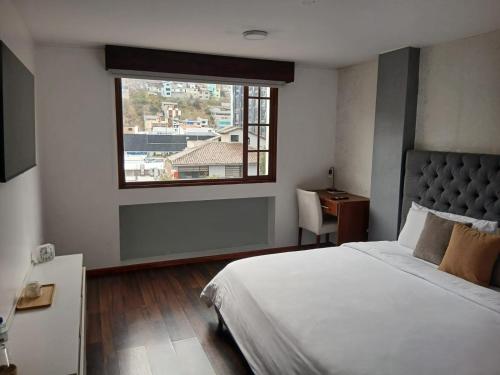 ein Schlafzimmer mit einem großen Bett und einem Fenster in der Unterkunft Hotel Ficoa in Ambato