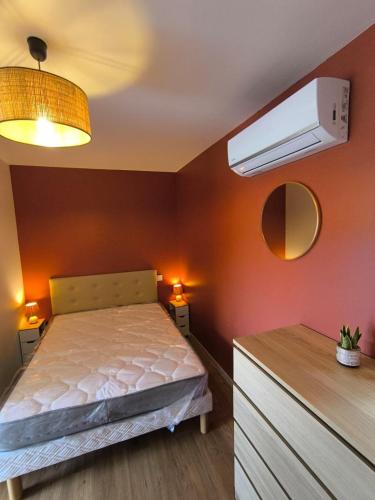 a bedroom with a bed and a air conditioner at Le Cocon de Sévérac I Clim & cour intérieure in Sévérac d' Aveyron