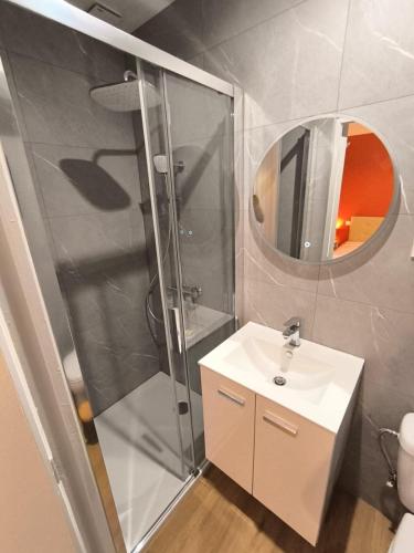 a bathroom with a shower and a sink and a mirror at Le Cocon de Sévérac I Clim & cour intérieure in Sévérac d' Aveyron