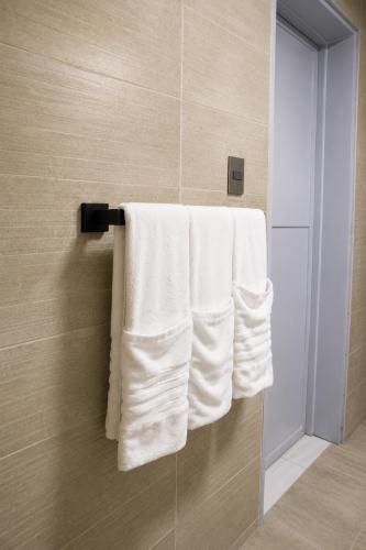 a group of towels hanging on a towel rack in a bathroom at Skylight Suites Hotel in San Felipe de Puerto Plata