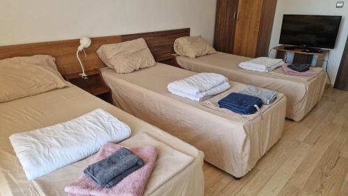 a room with three beds and a flat screen tv at Beach View Apartment Chernomorec in Chernomorets