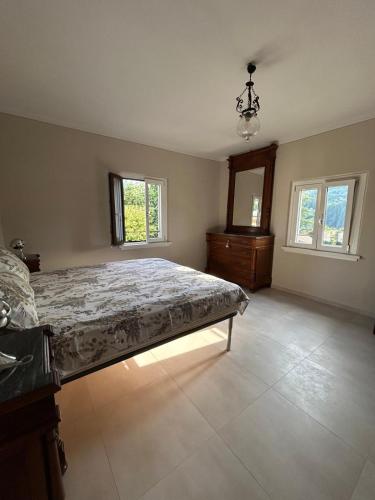 a bedroom with a bed and two windows at San Leo Apartment in Stia