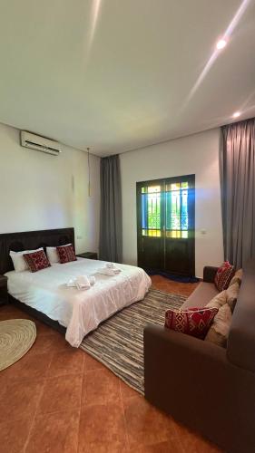 a bedroom with a large bed and a couch at Villa Riad Ambre in Douar bel Rhanodour
