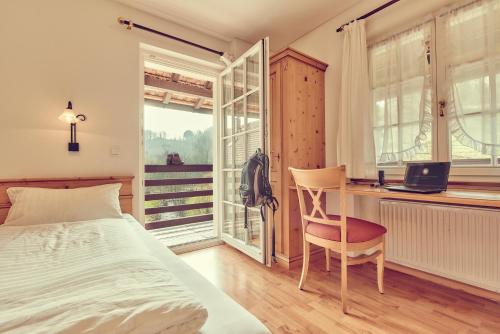 a bedroom with a bed and a desk with a laptop at Landgasthof zur Sonne in Wehr