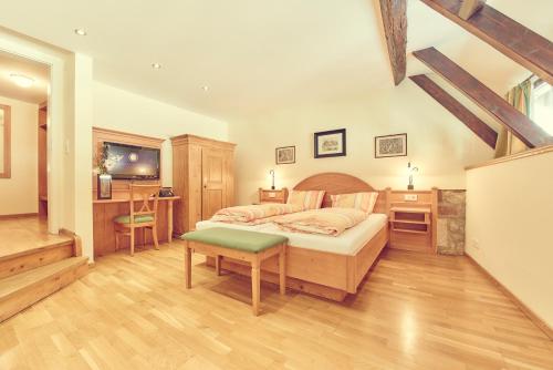 a bedroom with a bed and a desk and a tv at Landgasthof zur Sonne in Wehr
