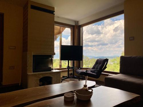 a living room with a couch and a chair in front of a window at Vila Vlasinski mir in Surdulica