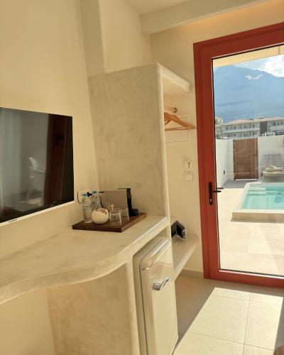 a kitchen with a window and a door to a pool at Xanthos Beachfront Suites in Potamiá