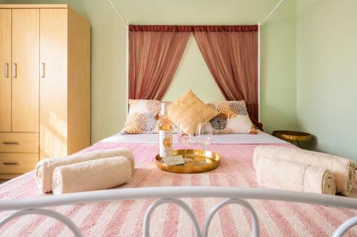a bed with a table with a bottle and glasses on it at Goldtown House in Chrysoupolis