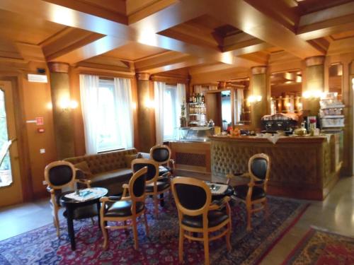 a living room with a couch and a table and chairs at Hotel Auronzo in Auronzo di Cadore