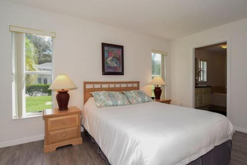 a bedroom with a bed and two lamps and a window at Villa Mourik in Inverness