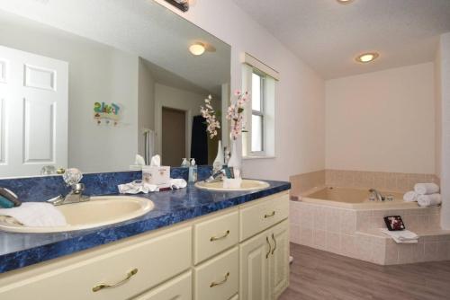 a bathroom with two sinks and a bath tub at Villa Mourik in Inverness